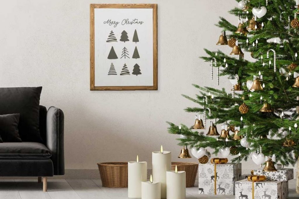 Amuebla tu hogar en Navidad.  Salón con sofá negro y árbol de Navidad con velas blancas.