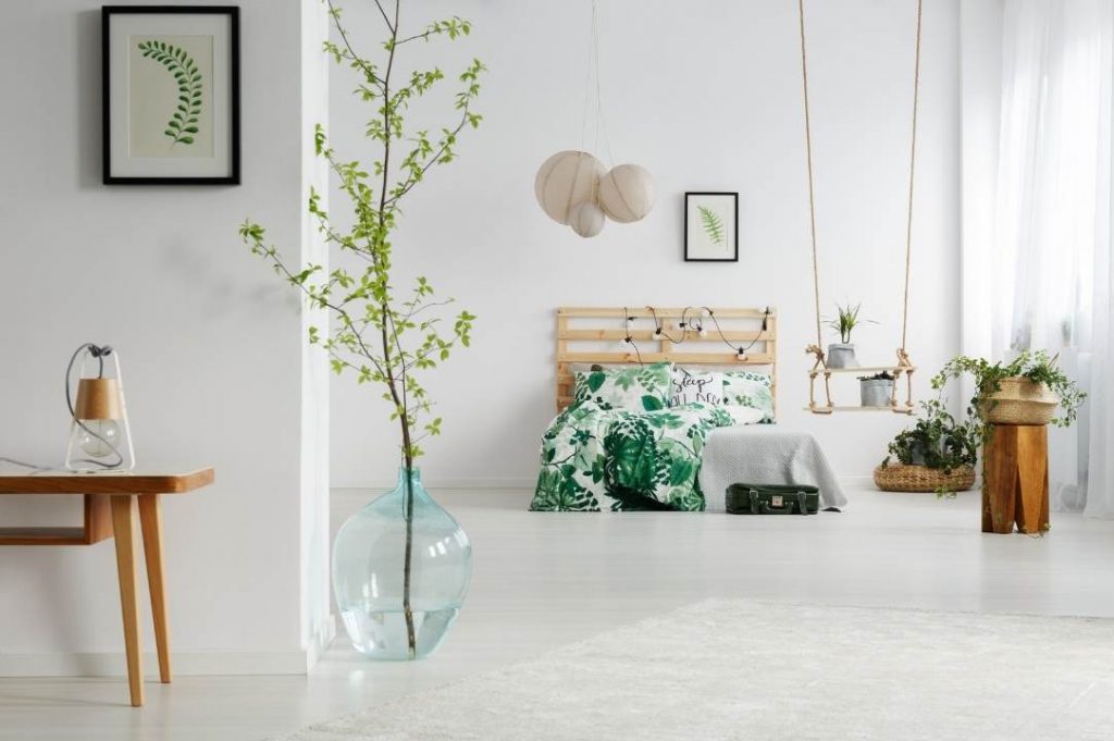 Dormitorio minimalista con muebles de madera de bambú claro y diseño floral.